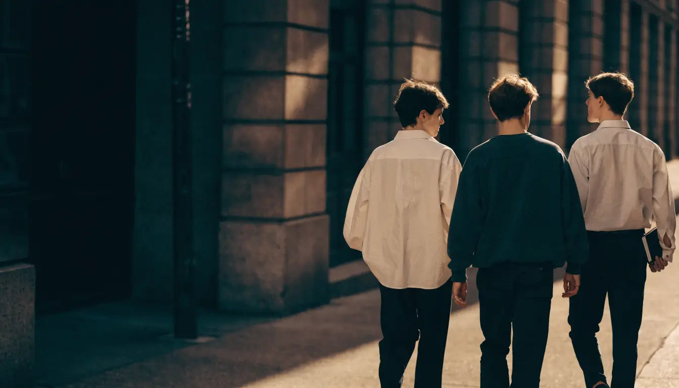 Three young friends seen from behind walking together through the city